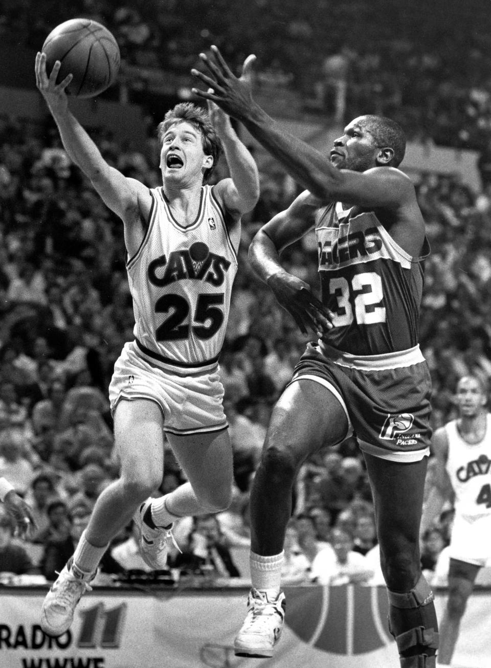 The Cleveland Cavaliers' Mark Price, left, looks for a layup ahead of the Indiana Pacers' Herb Williams at the Richfield Coliseum, April 18, 1988, in Richfield, Ohio.