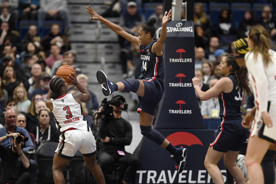 NC State's Diamond Johnson (3) shoots as Connecticut's Aubrey Griffin (44) defends during the first half of an NCAA basketball game, Sunday, Nov. 20, 2022, in Hartford, Conn. (AP Photo/Jessica Hill)