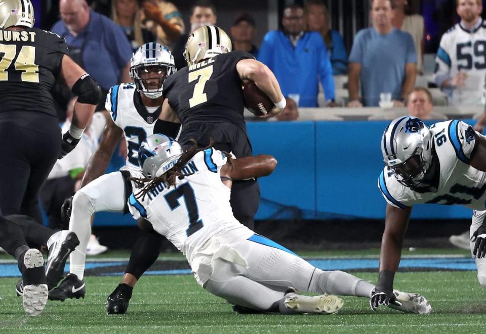 Carolina Panthers linebacker Shaq Thompson, center, fights to make the tackle on New Orleans Saints quarterback Taysom Hill during first-quarter action against at Bank of America Stadium on Monday, September 18, 2023. The Panthers lost to the Saints 20-17. Thompson would fracture his fibula on the play.