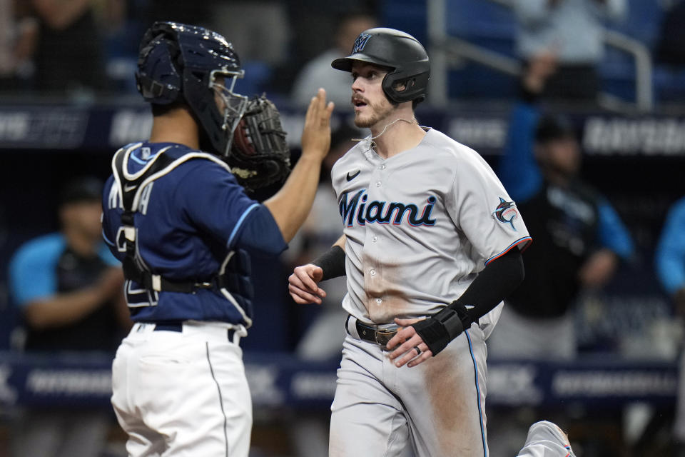 Miami Marlins' Brian Anderson, right, scores in front of Tampa Bay Rays catcher Francisco Mejia on a two-run double by Jacob Stallings during the fourth inning of a baseball game Wednesday, May 25, 2022, in St. Petersburg, Fla. (AP Photo/Chris O'Meara)