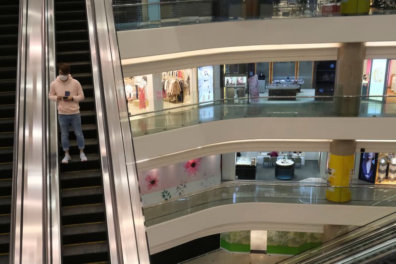 A man wearing protective mask rides an escalator at Times Square shopping centre, following the outbreak of the new coronavirus, in Hong Kong