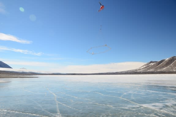 A helicopter flies a transmitter across Lake Frxyell, Antarctica.