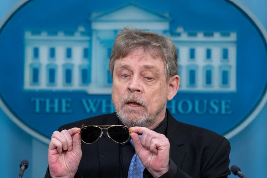 Actor Mark Hamill takes off sunglasses given to him by President Joe Biden, as he joins White House press secretary Karine Jean-Pierre as she speaks with reporters in the James Brady Press Briefing Room at the White House, Friday, May 3, 2024, in Washington. (AP Photo/Alex Brandon)