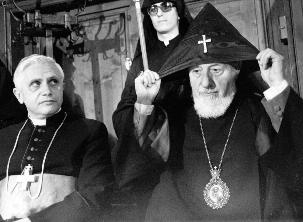 FILE - German Cardinal Joseph Ratzinger, left, head of the Vatican's watchdog body on doctrine, looks on while the head of the Armenian-Orthodox Church, Vasken I Baldyan, adjusts his hood, in Munich, Germany, in 1981. Ratzinger went on to become Pope Benedict XVI. Pope Emeritus Benedict XVI, the German theologian who will be remembered as the first pope in 600 years to resign, has died, the Vatican announced Saturday. He was 95. (AP Photo, File)