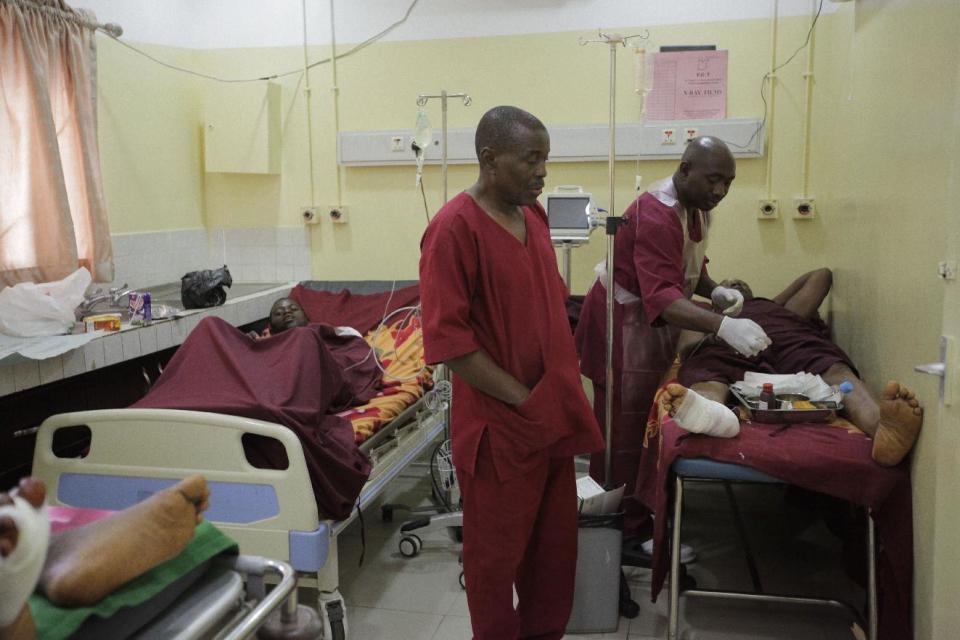 Paramedics treat a victim of Monday's explosion at Asokoro hospital in Abuja, Nigeria, Tuesday, April 15, 2014, with dozens feared dead as the blast destroyed more than 30 vehicles and caused secondary explosions as their fuel tanks exploded and burned. The Monday attack just miles from Nigeria's seat of government increases doubts about the military's ability to contain an Islamic uprising that is dividing the country on religious lines as never before. (AP Photo/ Sunday Alamba)