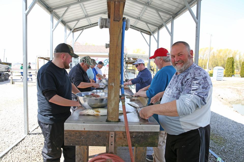 Storm Langholff, left, and Johnathan Hartwig, along with their crew, all from Fort Adkinson, Wisconsin, clean their morning catch of walleye, at Shatto's Fish Cleaning near Oak Harbor.