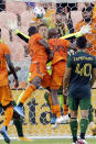 Houston Dynamo's Maynor Figueroa (15) and Fafa Picault (10) both go for a header for a goal as Portland Timbers goalkeeper Aljaz Ivacic, back, attempts to block during the first half of an MLS soccer match Wednesday, June 23, 2021, in Houston. Picault was credited with the goal. (AP Photo/Michael Wyke)