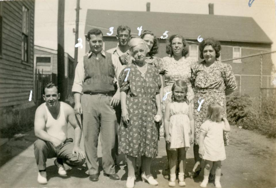 Among this group standing in front of what is now the Drisco-Shapley-Pridham house on Puddle Lane (formerly Charles Street) in Strawbery Banke are Sherman Pridham's uncle, Joseph Pridham (1); Pridham's father, Sherman C. Pridham (2);  uncle Reginald Dow (3); mother Blanche Jones Pridham (4); aunt Hazel Jones Pridham (5); aunt Alice Pridham Dow (6); paternal grandmother Louise Condon Pridham (7); Jane Dow (8); and Judy Beasley (9). The Players' Ring Building on Marcy Street is in the background.