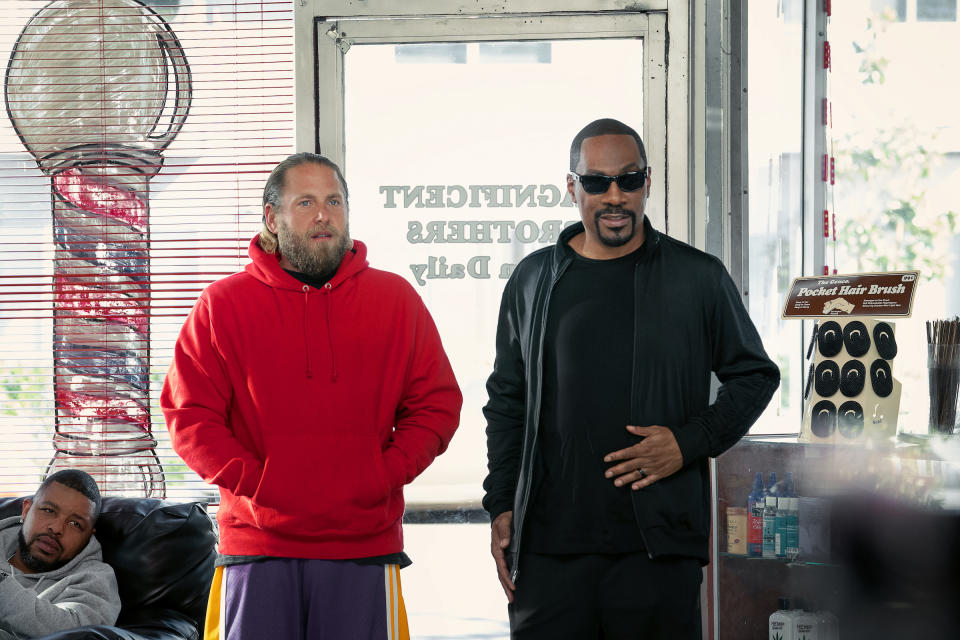 Jonah Hill's Ezra wearing a red hoodie in a Crip-territory barber shop to which Eddie Murphy's Akbar has brought him<span class="copyright">Tyler Adams/Netflix</span>