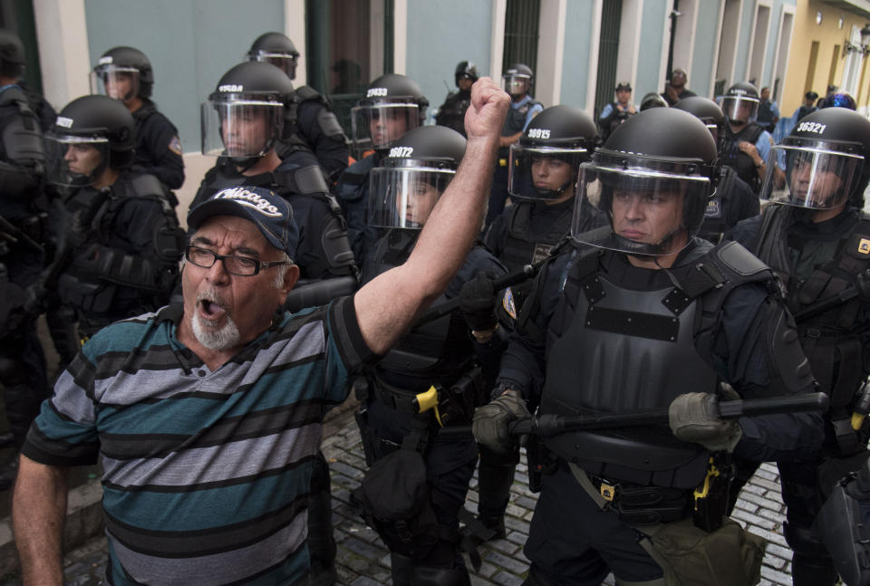 Police block demonstrators from advancing to La Fortaleza governor's residence in San Juan, Puerto Rico, Sunday, July 14, 2019. Protesters are demanding Gov. Ricardo Rosselló step down for his involvement in a private chat in which he used profanities to describe an ex-New York City councilwoman and a federal control board overseeing the island's finance. (AP Photo/Carlos Giusti)
