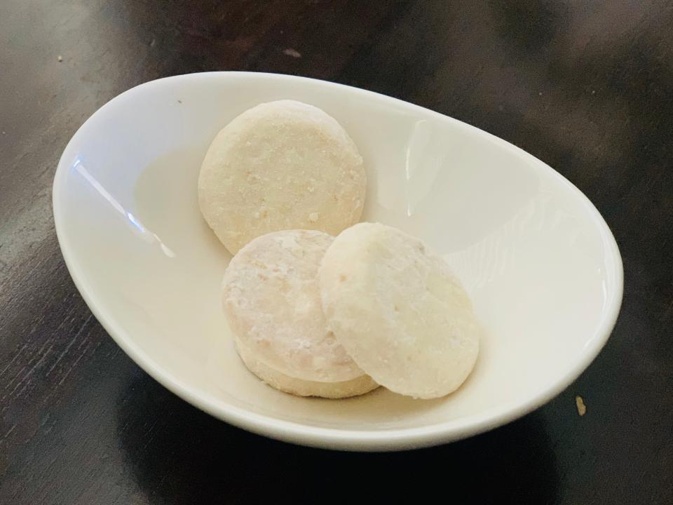 3 Trader Joe's key-lime tea cookies in a small white bowl on a dark wood table