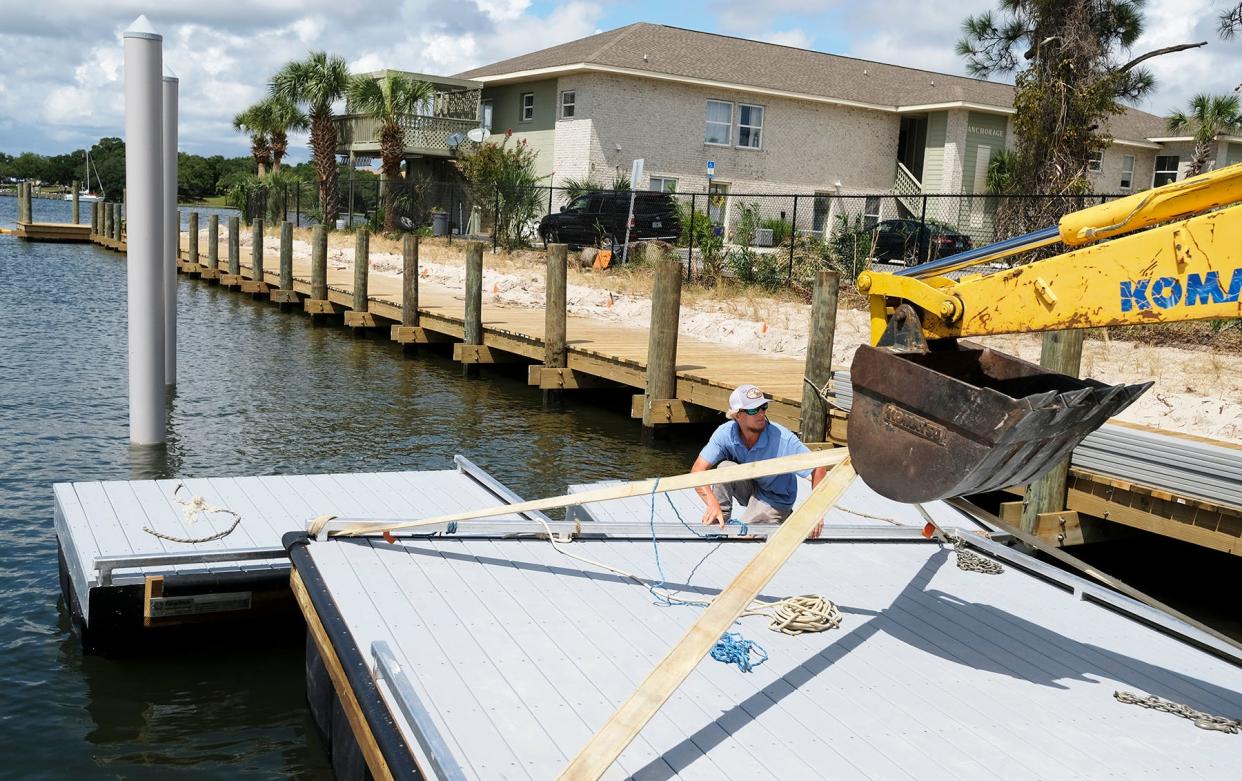 Zack Hennecke secures kayak/paddleboard launch floats at Boat Basin Two on Okaloosa Island. Renovations are now expected to be completed in late August.