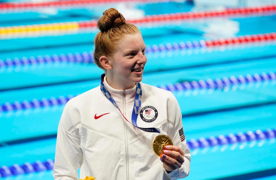 Lydia Jacoby holdsup her gold medal after winning the women's 100-meter breaststroke.