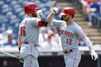 Cincinnati Reds' Tyler Naquin (12) celebrates with Colin Moran (16) after hitting a solo home run against the Cleveland Guardians during the fifth inning of a baseball game, Thursday, May 19, 2022, in Cleveland. (AP Photo/Ron Schwane)