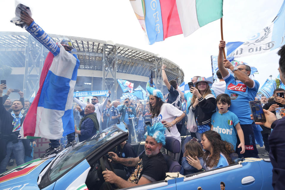 Napoli fans celebrate outside the Diego Maradona stadium in Naples, Italy, Sunday, April 30, 2023. After Napoli's game was moved to Sunday, the team could secure the title in front of their own fans by beating Salernitana — if Lazio fails to win at Inter Milan earlier in the day. Diego Maradona led Napoli to its only previous Serie A titles in 1987 and 1990. (AP Photo/Gregorio Borgia)