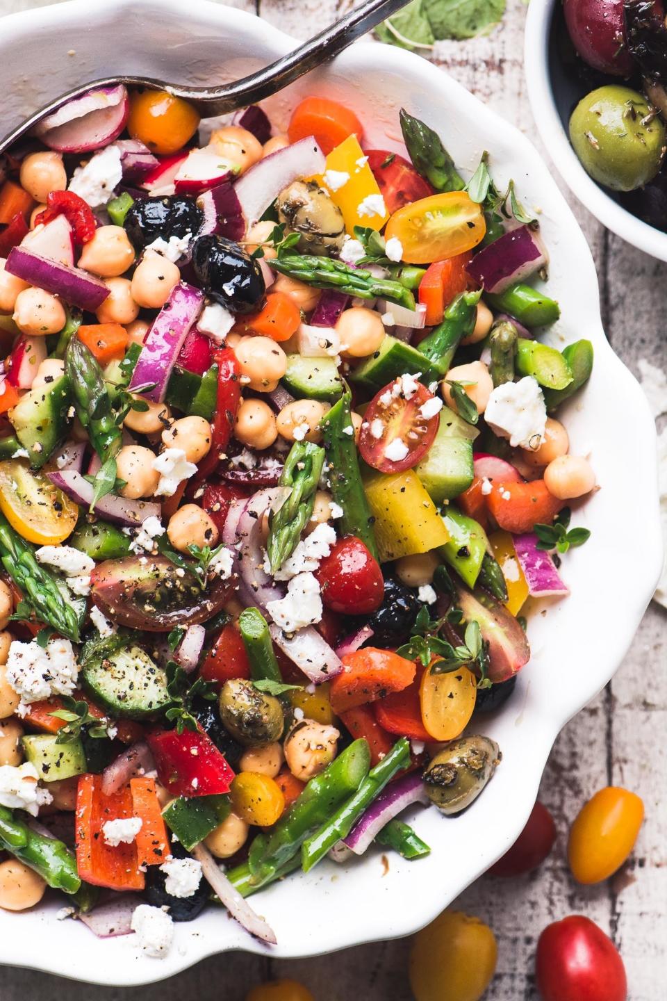 Asparagus salad with colorful vegetables, chickpeas, and feta.