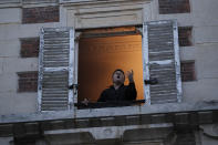 French tenor singer Stephane Senechal sings from his apartment window in Paris, March 24, 2020. (AP Photo/Francois Mori)