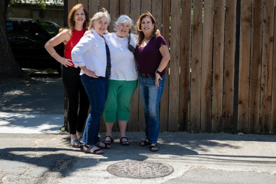 Sisters, Sally Styles-Zanotti, left, Linda Moore, Glory Styles and Katy Styles-Rogers, right, stand in July by a manhole cover from Berry’s Foundry that was founded by their great-grandfather.