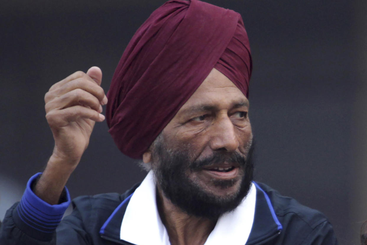 FILE - In this Dec. 15, 2013, file photo, former Indian athlete Milkha Singh, with, and Bollywood actor Bipasha Basu waves to the participants during the Delhi Half Marathon in New Delhi, India. Milkha Singh, one of India’s first sport superstars and ace sprinter who overcame fought a childhood tragedy and became the country's most celebrated athlete, has died. He was 91.(AP Photo/Tsering Topgyal, File)