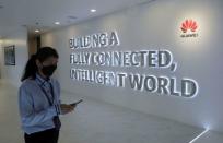 FILE PHOTO: A Huawei's staff uses her smartphone at the telecommunication company's Customer Experience Centre in Kuala Lumpur