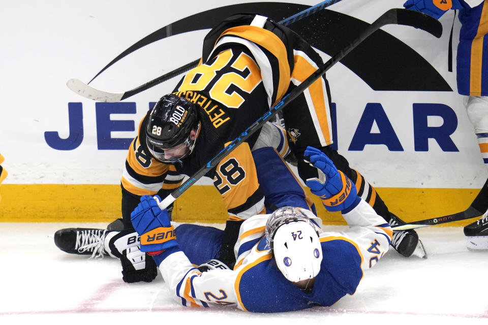 Pittsburgh Penguins' Marcus Pettersson (28) checks Buffalo Sabres' Dylan Cozens during the first period of an NHL hockey game in Pittsburgh, Saturday, Nov. 11, 2023. (AP Photo/Gene J. Puskar)