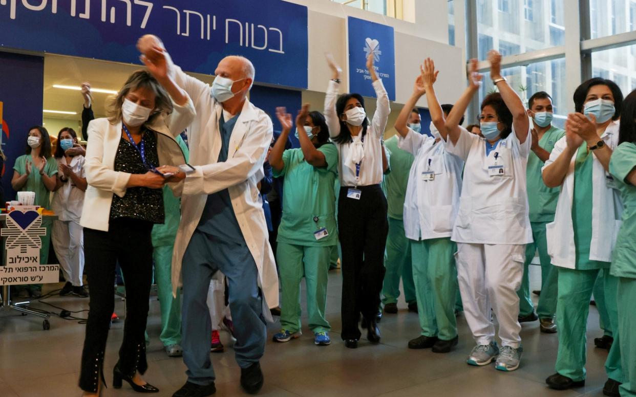 Medical teams celebrate before receiving coronavirus vaccines as Israel kicks off its coronavirus vaccination drive, at Tel Aviv Sourasky Medical Center - Ronen Zvulun/Reuters