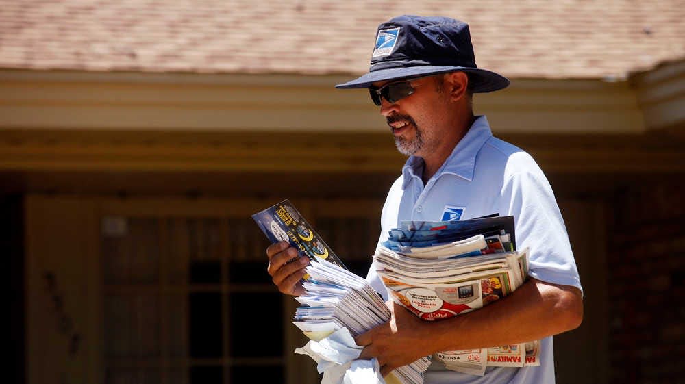 In this undated file photo, United States Postal Service worker Britt Fausler delivers mail along 58th Street in Lubbock.