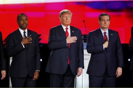 Republican U.S. presidential candidates (L-R) Dr. Ben Carson, businessman Donald Trump and Senator Ted Cruz hold their hands over their hearts for the singing of the U.S. national anthem before the start of the Republican presidential debate in Las Vegas, Nevada December 15, 2015. REUTERS/Mike Blake