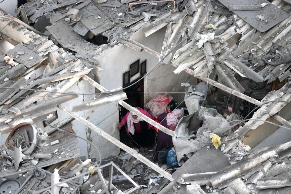 Palestinians check the destruction following Israeli bombardment in Rafah, in the southern Gaza Strip on December 12, 2023.