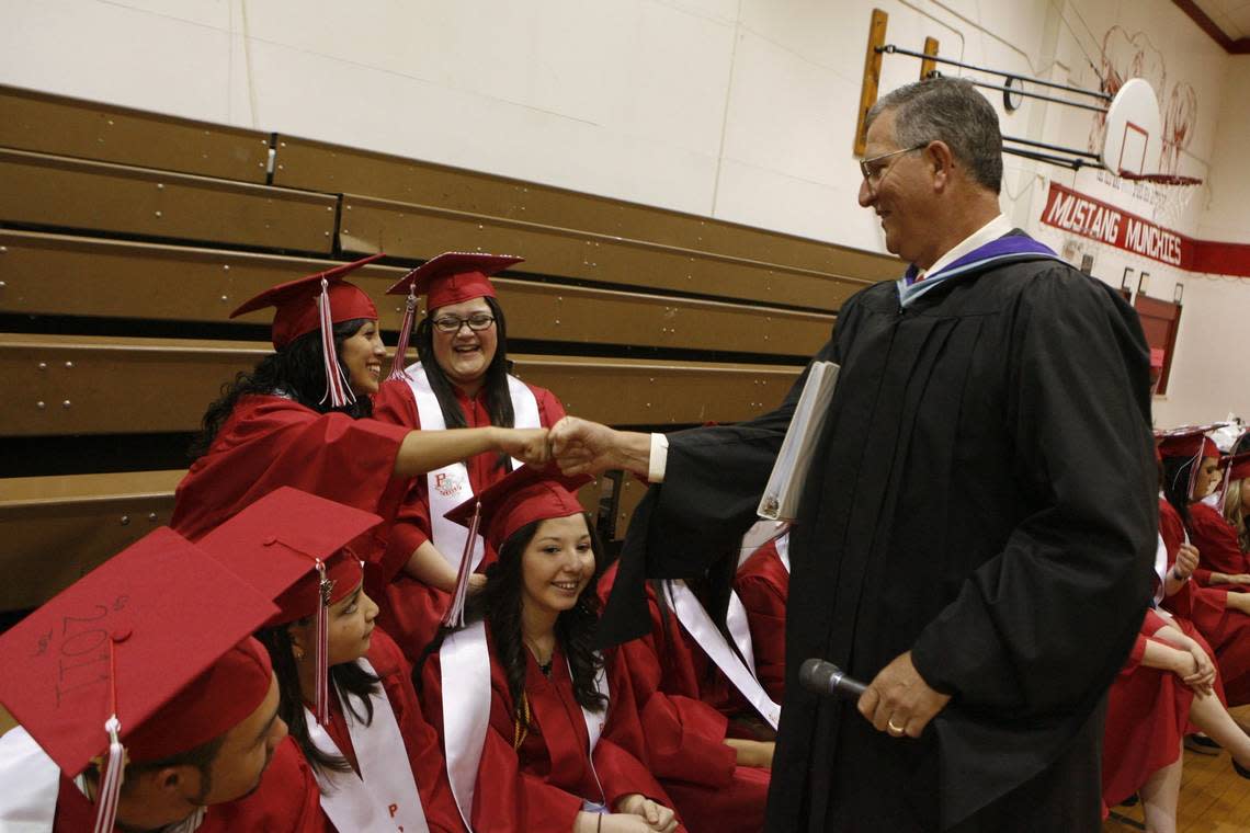 In 2011, then-Principal Kevin Lusk bumps fists with students during Prosser High School’s graduation ceremony.