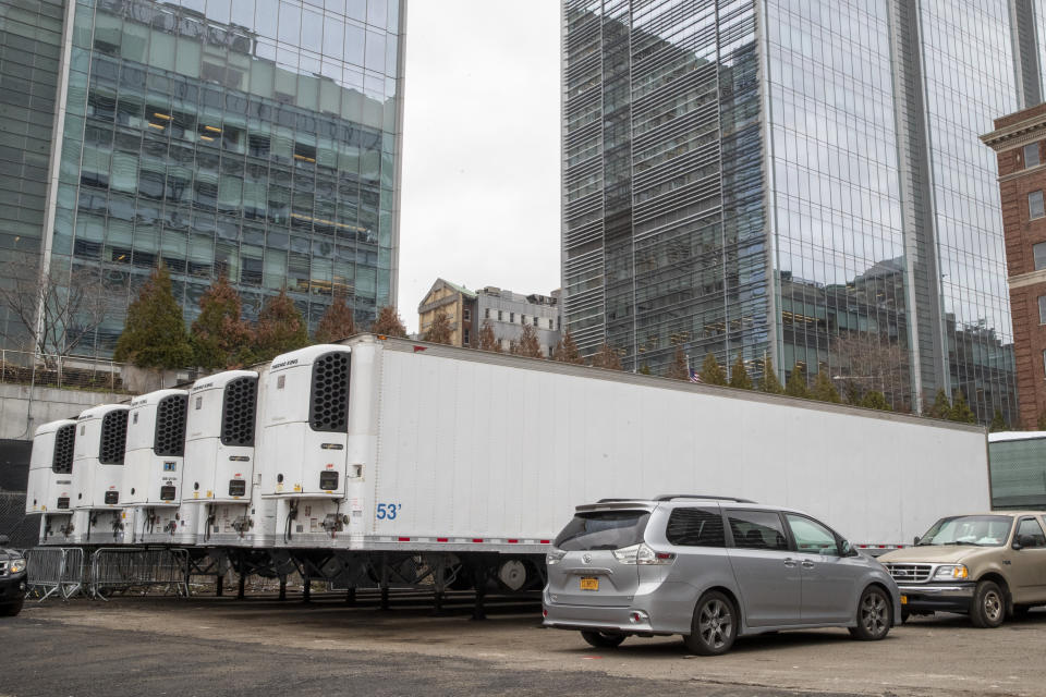 Refrigerated trailers are seen parked at the site of a makeshift morgue being built in New York, Wednesday, March 25, 2020.  New York officials are keeping a close eye on already-stressed hospitals as the number of cases is projected to rise for perhaps three more weeks. The new coronavirus causes mild or moderate symptoms for most people, but for some, especially older adults and people with existing health problems, it can cause more severe illness or death. (AP Photo/Mary Altaffer)