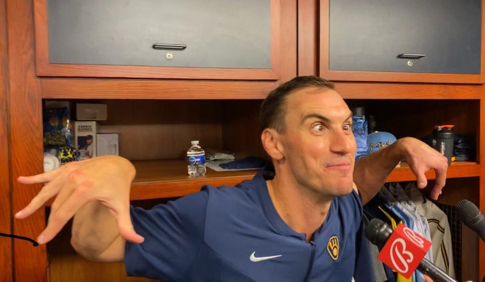 Milwaukee Brewers pitcher Brent Suter reenacts the signal manager Craig Counsell gave for him to warm up with the bullpen phone down.