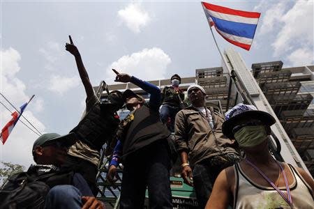 Anti-government protesters scan the area as they gather at a Defence Ministry compound, which is serving as a temporary office for Prime Minister Yingluck Shinawatra, in north Bangkok February 19, 2014. REUTERS/Damir Sagolj