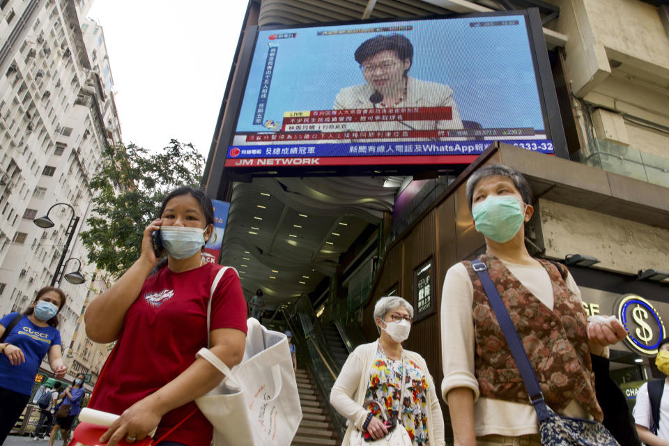 A TV screen broadcasts Hong Kong Chief Executive Carrie Lam during a news conference in Hong Kong, Tuesday, March 30, 2021. China's top legislature approved amendments to Hong Kong's constitution on Tuesday that will give Beijing more control over the makeup of the city's legislature. (AP Photo/Vincent Yu)