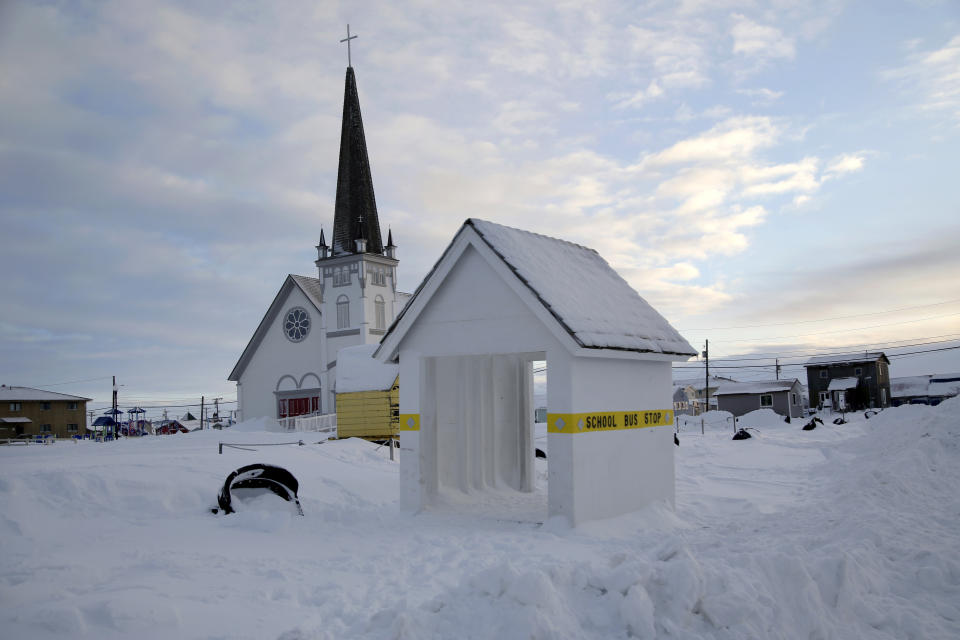 In this Feb. 14, 2019, photo, a school bus stop stands in front of Old St. Joe's Hall, built in 1901 by a Jesuit priest in Nome, Alaska. (AP Photo/Wong Maye-E)