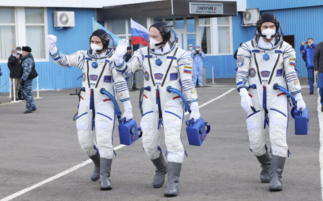 In this photo released by Roscosmos Space Agency, Russian cosmonauts, commander Оleg Аrtemyiv, centre, flight engineers Denis Мatveev, right, and Sergei Korsakov, members of the main crew to the International Space Station (ISS), walk prior to the launch at the Baikonur Cosmodrome, Kazakhstan, Friday, March 18, 2022. (Roscosmos Space Agency via AP)