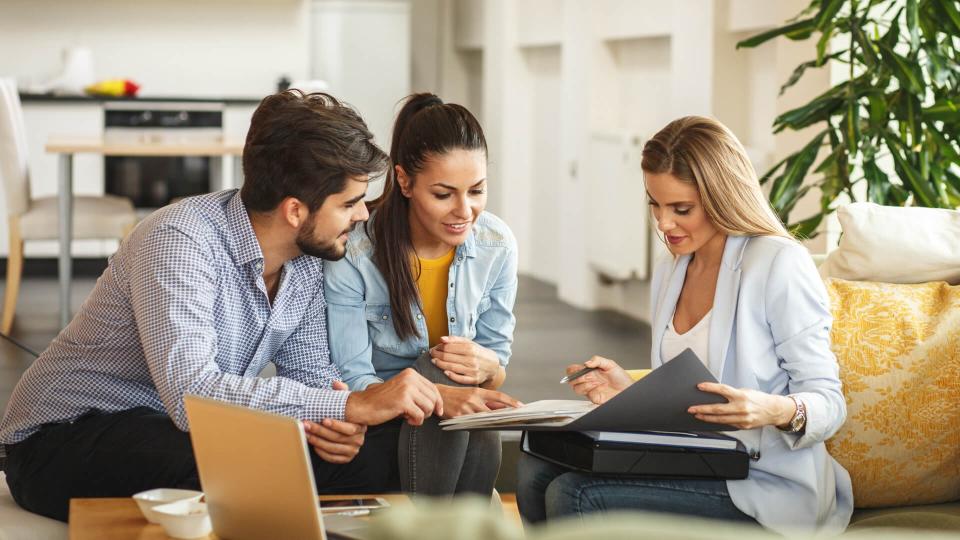 Female Real Estate agent offer home ownership and life insurance to young couple.