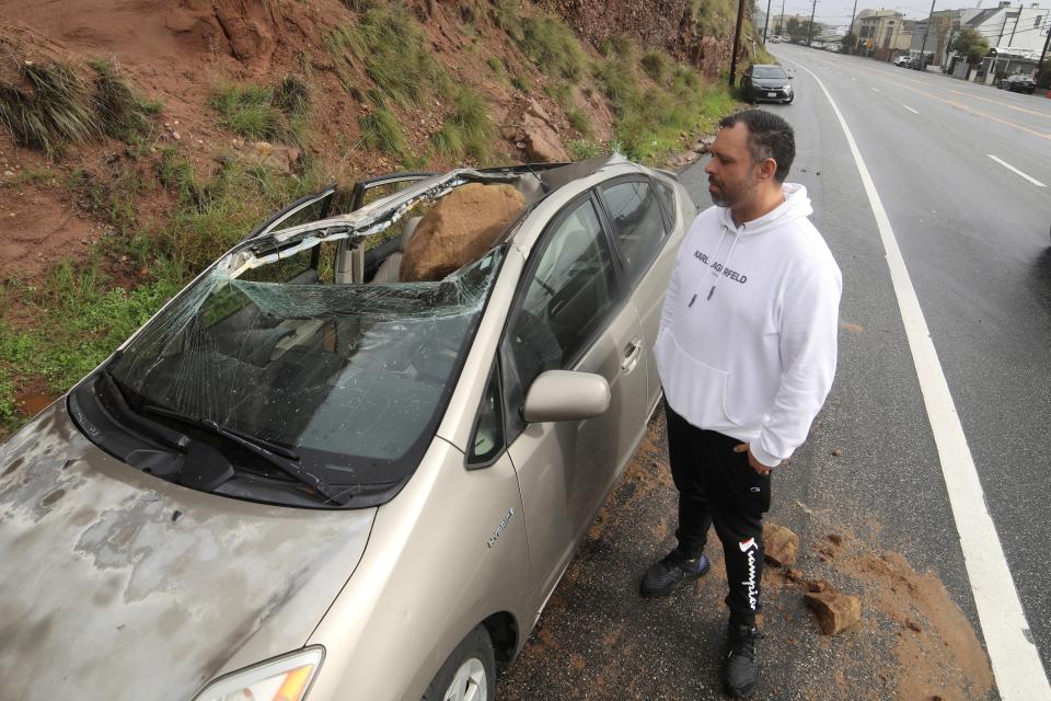 Owner Maurice Henao looks at the small boulder resting in his vehichle parked along the Pacific Coastal Highway in Malibu, California on January 10 (REUTERS)