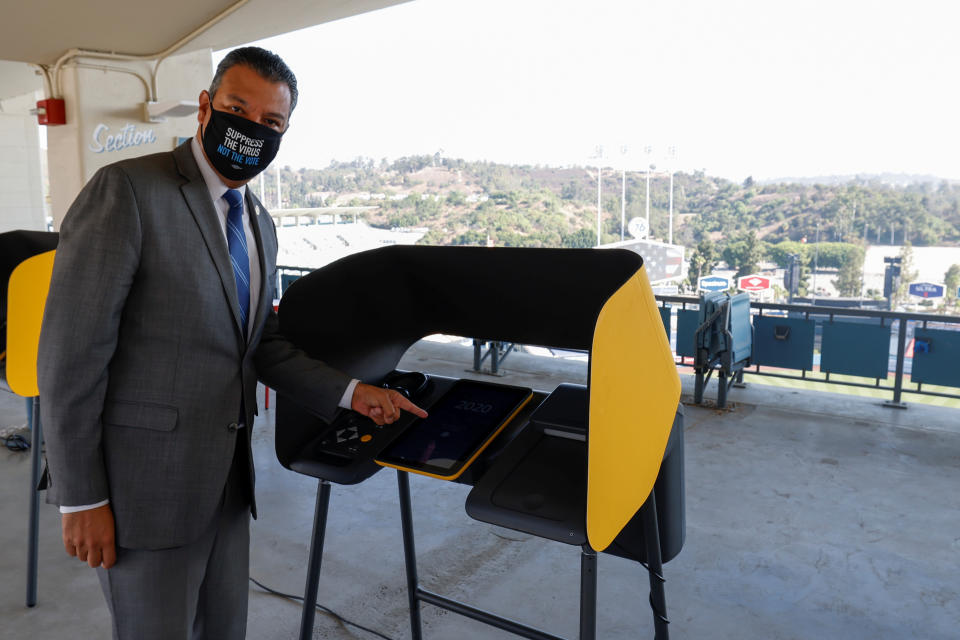 California Secretary of State Alex Padilla points to a voting booth at the Vote Center being set up for the U.S. general election at Dodger Stadium in Los Angeles, California, U.S., September 24, 2020.   REUTERS/Mike Blake