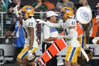 Pittsburgh defensive back Javon McIntyre (20) celebrates with defensive back Jehvonn Lewis (41) after getting an interception during the first half of an NCAA college football game against Miami, Saturday, Nov. 26, 2022, in Miami Gardens, Fla. (AP Photo/Lynne Sladky)