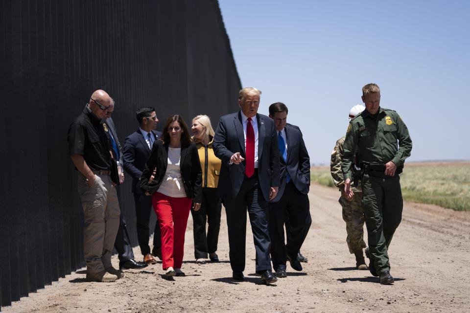 El presidente Donald Trump recorre una sección del muro fronterizo con el jefe de la Patrulla Fronteriza, Rodney Scott, en San Luis, Arizona, el martes 23 de junio de 2020. (AP Foto/Evan Vucci)