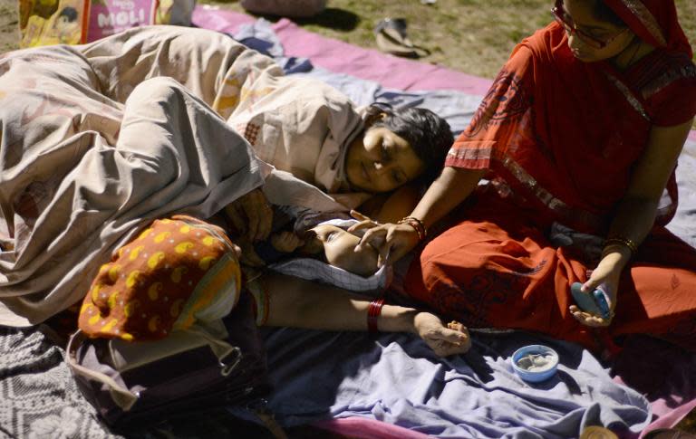 Indian residents rest and sleep in a football field in Siliguri