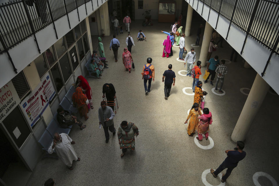 People stand on social distancing markings made as a precaution against the coronavirus at a government hospital in Jammu, India, Monday, April 19, 2021. India now has reported more than 15 million coronavirus infections, a total second only to the United States. (AP Photo/Channi Anand)