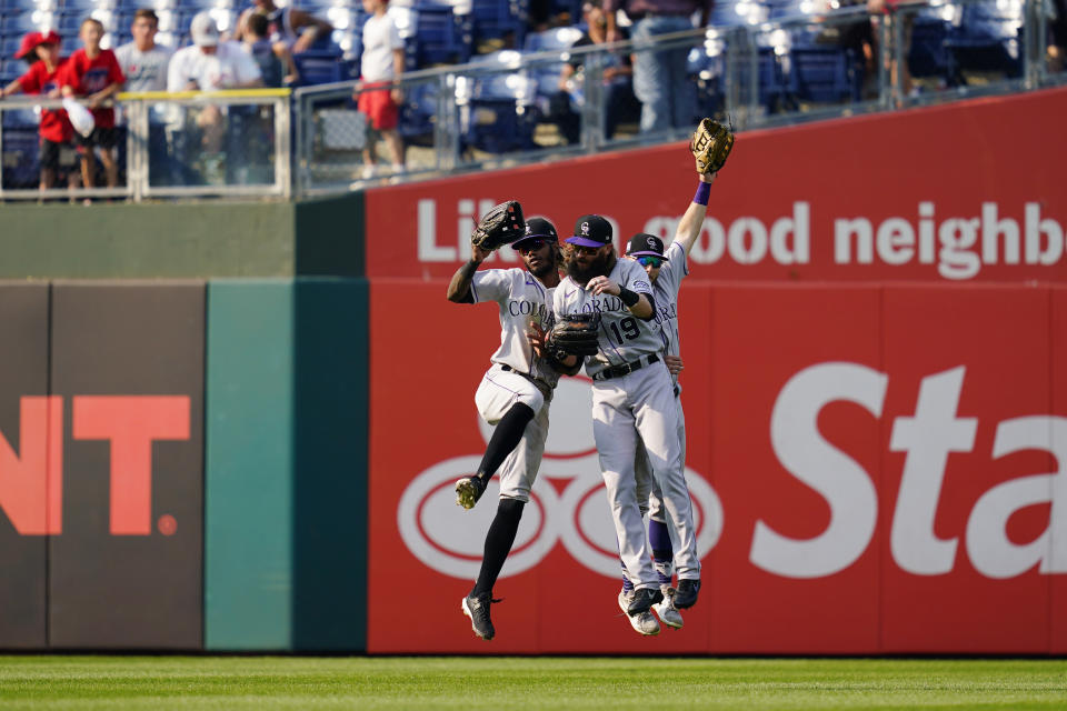 Colorado Rockies' Raimel Tapia, from left, Charlie Blackmon and Garrett Hampson celebrate after a baseball game against the Philadelphia Phillies, Sunday, Sept. 12, 2021, in Philadelphia. (AP Photo/Matt Slocum)