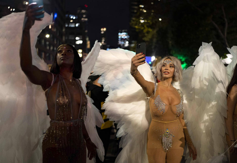 FILE - Costumed Halloween revelers take pictures with their phones before the start of New York City's 48th annual Greenwich Village Halloween Parade, Sunday, Oct. 31, 2021, in New York. (AP Photo/Dieu-Nalio Chery, File)