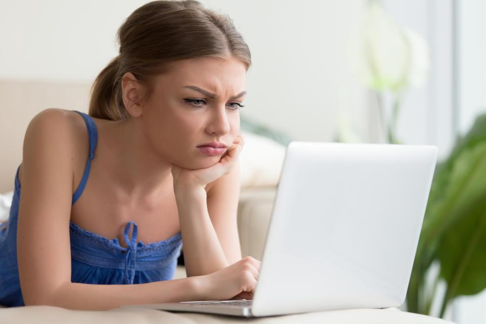 Frustrated woman looking at laptop