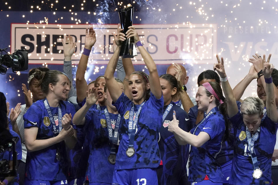 ARCHIVO - La delantera estadounidense Alex Morgan (centro) alza el trofeo de la SheBelieves Cup tras vencer 2-0 a Brasil, el miércoles 22 de febrero de 2023, en Frisco, Texas. (AP Foto/LM Otero)