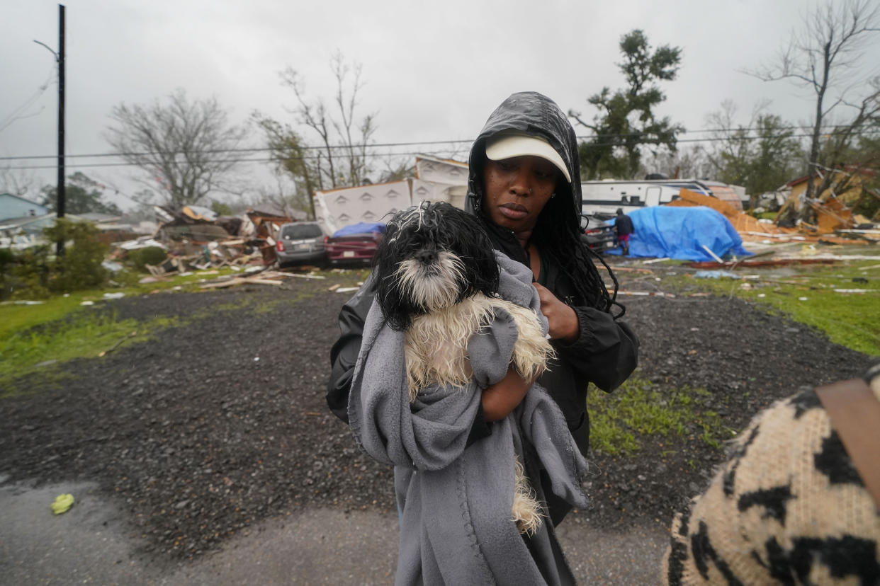 CORRECTS LAST NAME TO BOVIE NOT BOVIEM - Chelsi Bovie holds her niece's dog that she rescued from her home after a tornado tore through the area in Killona, La., about 30 miles west of New Orleans in St. James Parish, Wednesday, Dec. 14, 2022. (AP Photo/Gerald Herbert)