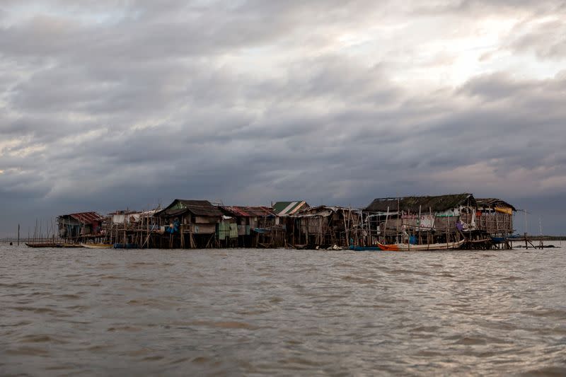 The Wider Image: Rising seas threaten early end for sinking village in Philippines