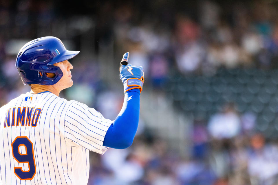 New York Mets' Brandon Nimmo points to the sky while at first base during the eighth inning of a baseball game against the Pittsburgh Pirates, Sunday, Sept. 18, 2022, in New York. The Mets won 7-3. (AP Photo/Julia Nikhinson)